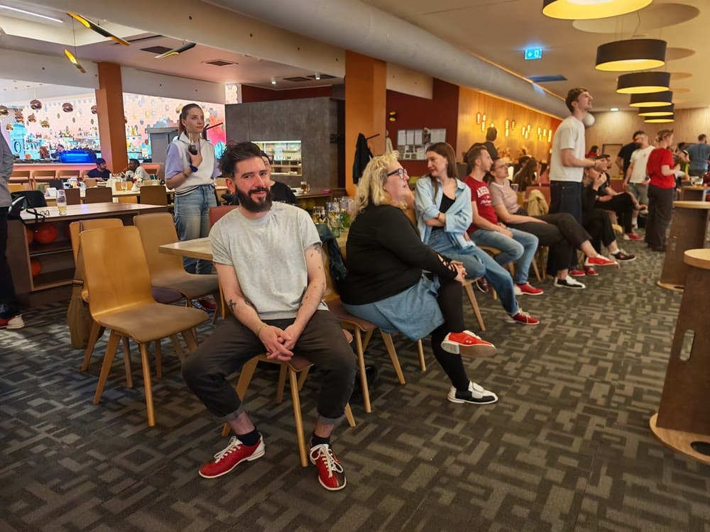Hosté brněnského bowlingu v bowlingových botách sledují hru